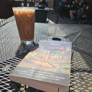 Person reading Sacramento Noir with coffee at Old Soul café in Oak Park, Sacramento